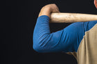 Close-up of a pitcher's shoulder holding a baseball bat, showcasing focus on arm strength and technique for improved pitching performance.