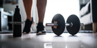 A focused gym scene featuring a dumbbell and a water bottle, emphasizing the role of essential and branched chain amino acids for strength and recovery in fitness.