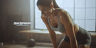 Focused woman engaging in an intense workout session, highlighting muscle definition and determination in a stylish gym setting.